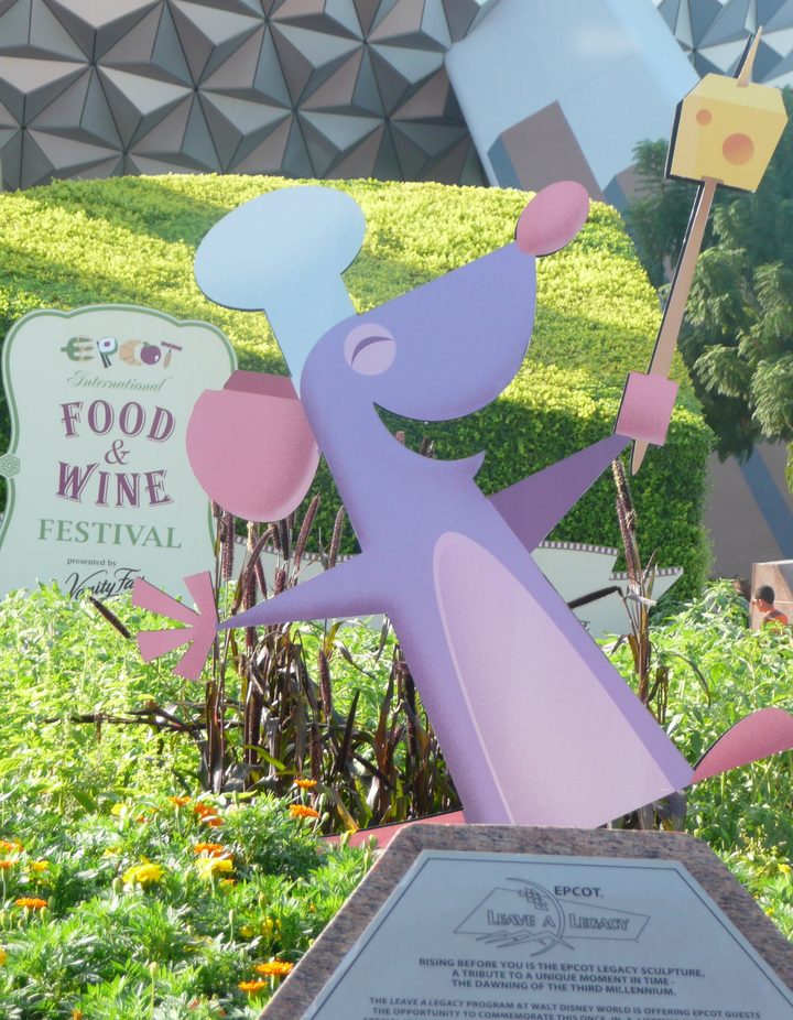 Chef Remy cutout raising a cheese wedge in front of Spaceship Earth